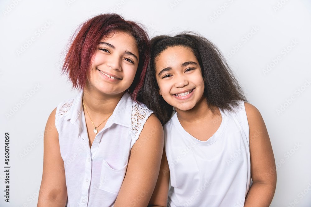 portrait of two beautiful sister over studio background portrait of two beautiful sister over studio background