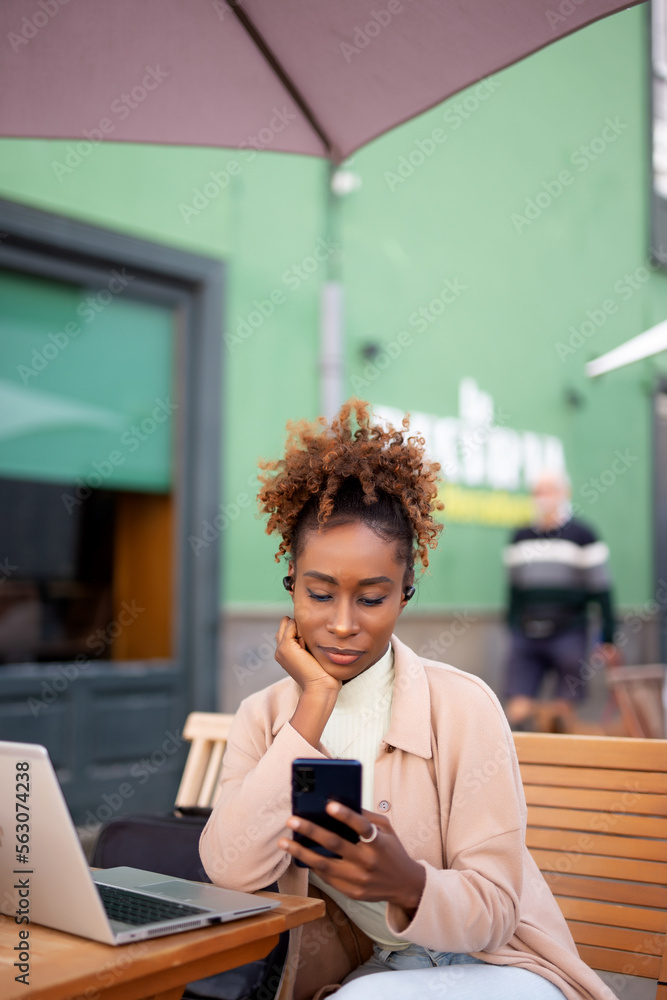 happy young woman using a mobile phone and earphones to make a call outdoor in the city happy young woman using a mobile phone and earphones to make a call outdoor in the city