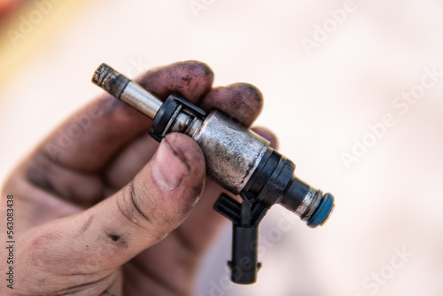 Dirty car injector in hands. Car repair concept. Increased fuel consumption. Car fuel