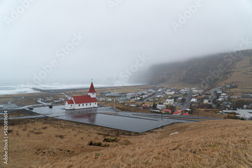 Vík í Mýrdal Church above coastal Icelandic village on a foggy day wide shot