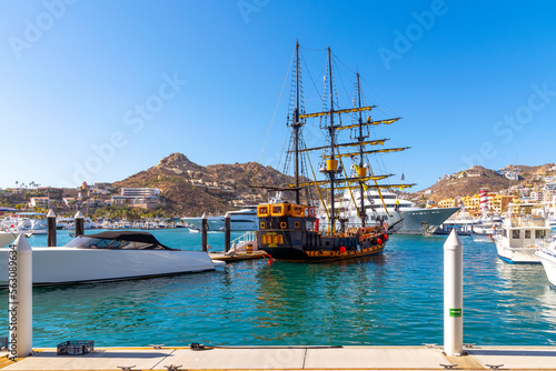 Fotografie A replica of a pirate ship sits among sailboats and luxury yachts at the marina at Cabo San Lucas, Mexico