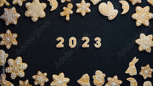 Christmas cookies on Black Craft background. Holiday backdrop. Gingerbread snowflake and numbers of the year. Top View