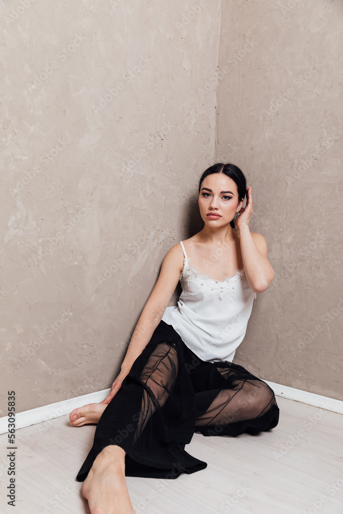 a brooding woman in black pants sits in a corner a brooding woman in black pants sits in a corner