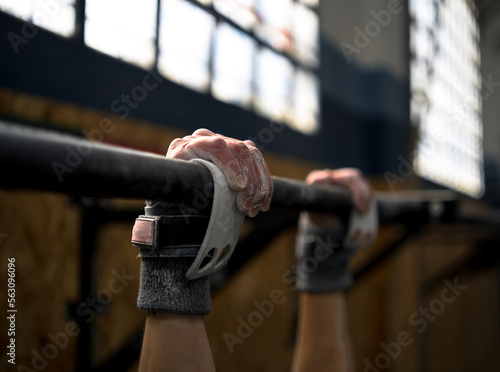 Foto Girl holding on to the bar to do wide pull-ups.