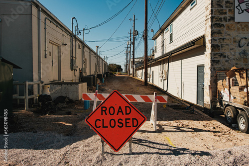 road closed sign in front of an alley under construction