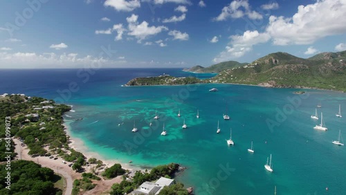 The drone aerial footage of Pigeon Point beach and Deep Bay beach in Antigua. The widely turquoise bay is surrounded by beautiful undulating slopes, and the iconic Fort Barrington.