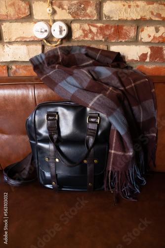 Leather retro backpack on the sofa on the background of the brick wall of the loft