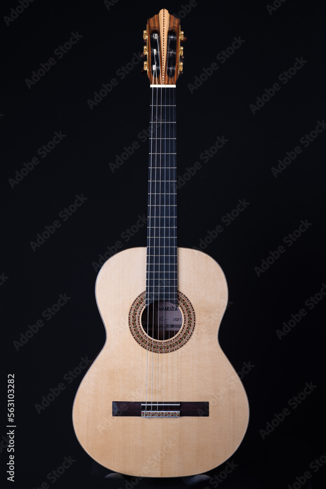 Classical guitar top isolated on black background, view from the top side. Beautiful Brazilian wood - Pau Ferro on the back and spruce on the top. Classic acoustic guitar concept. 