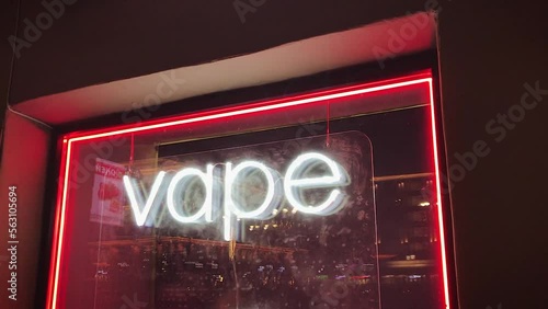 vape shop electronic cigarette neon colored window showcase sign lights glow up attracting customers on the street at night.concept vape shop.