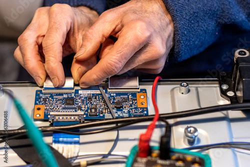 Electronics technician assembles components with his hands.
