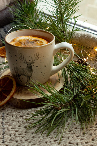 Green tea in a craft cozy cup, dried fruit, orange and cinnamon stick
