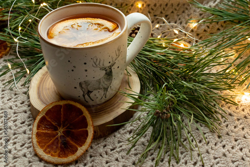 Green tea in a craft cozy cup, dried fruit, orange and cinnamon stick