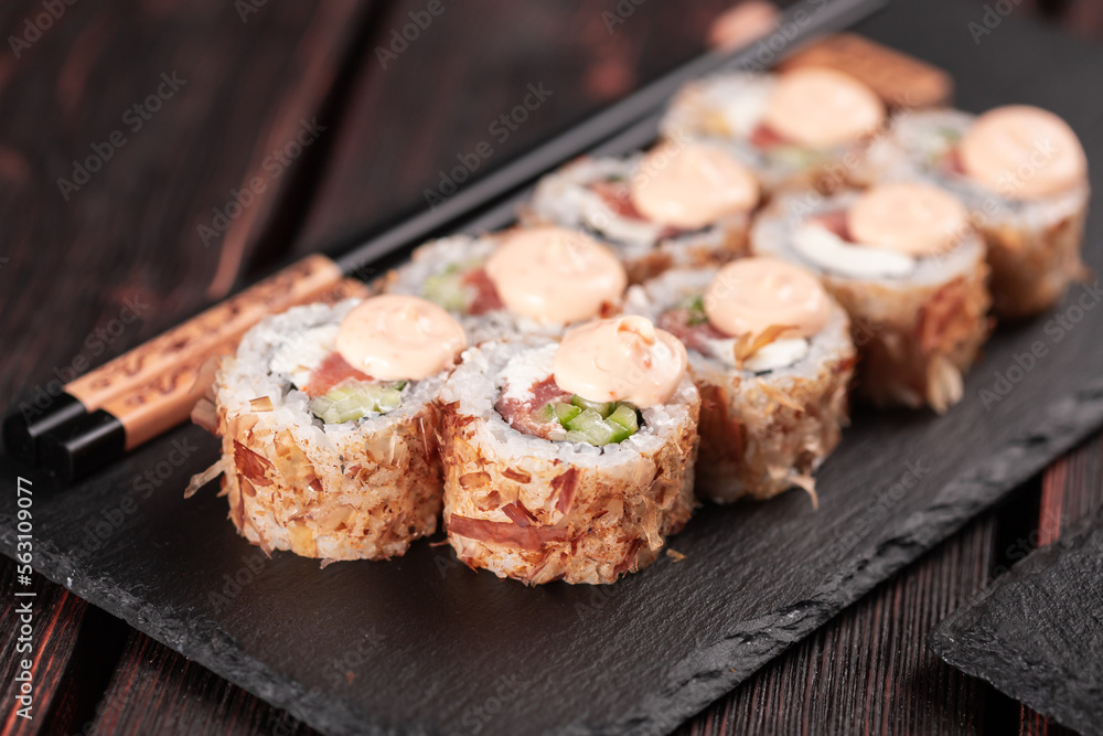 Salmon sushi roll with tuna flakes and souse close-up - sushi asian menu and Japanese food