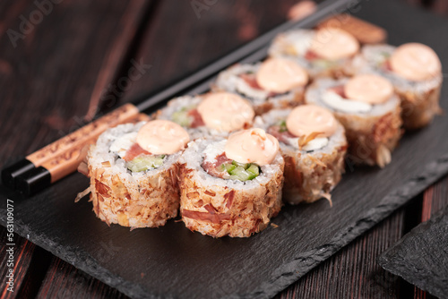 Salmon sushi roll with tuna flakes and souse close-up - sushi asian menu and Japanese food