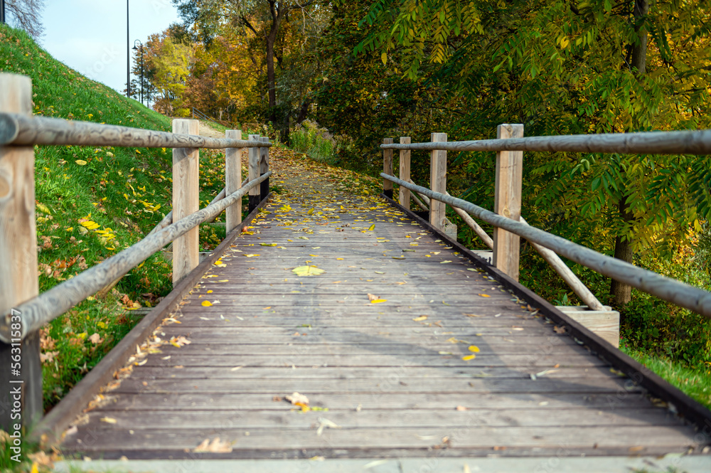 Wooden bridge for pedestrians next to a road in the countryside in autumn, Autumn landscape