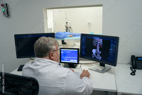 Doctor diagnostician conducts a CT examination of the patient