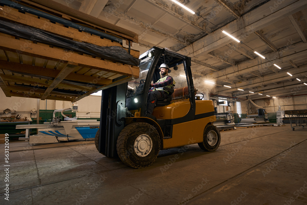 Loader transporting goods by car in the workshop
