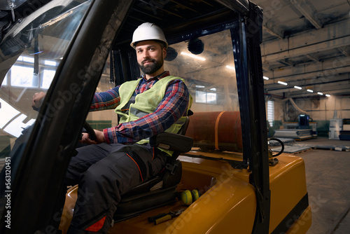 Worker transporting goods by car in the workshop