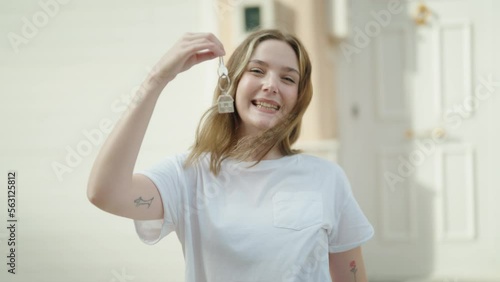 Wallpaper Mural Young caucasian woman smiling confident holding key of new home at street Torontodigital.ca