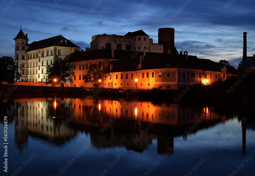 Night castle and castle with reflection in water.