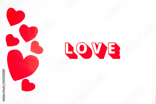 Imagen de corazones rojos recortados y la palabra Love sobre un fondo blanco aislado 
