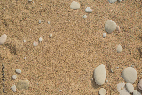 Feiner Sand mit hellen und runden Kieselsteinen