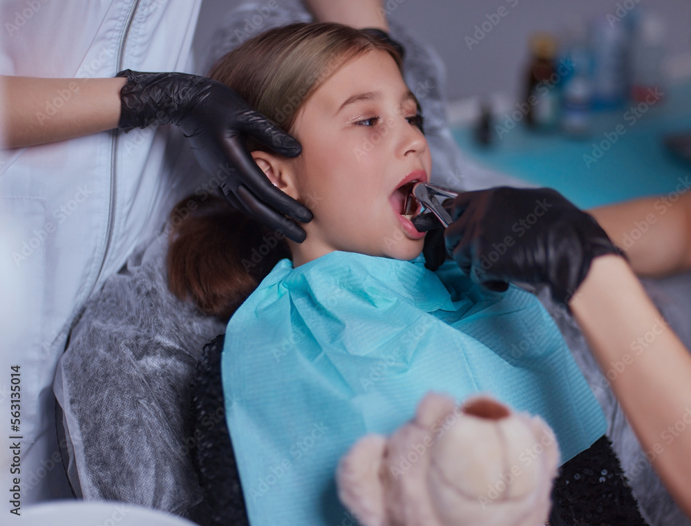 Dentist use anesthetic injection for tooth extraction in child. Stock