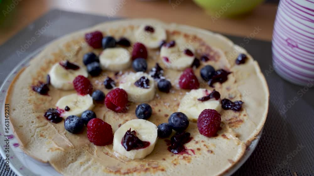 Top view of pancake with peanut butter spreading along with fruits such as banana, blueberries and raspberries covered with coconut flakes, healthy breakfast concept Top view of pancake with peanut butter spreading along with fruits such as banana, blueberries and raspberries covered with coconut flakes, healthy breakfast concept