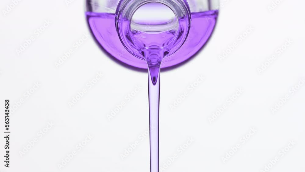 Abstract skincare cosmetics ingredients formulating concept | Side view macro shot of lavender oil is being poured from reagent bottle on grey background Abstract skincare cosmetics ingredients formulating concept | Side view macro shot of lavender oil is being poured from reagent bottle on grey background