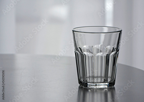 pusta szklanka na stole, empty glass, empty glass on the table in an empty room photo