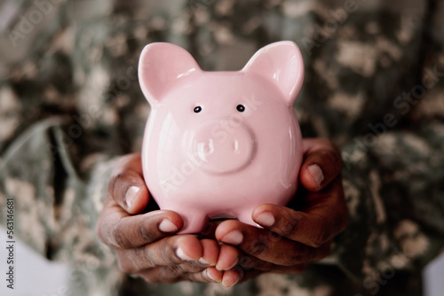 Soldier's Hand Holding Pink Piggy Bank