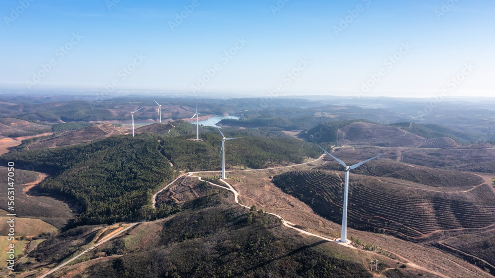 Wind turbines generate clean, green electricity in the fields of Portugal. With a view of the Bravura dam. Wind turbines generate clean, green electricity in the fields of Portugal. With a view of the Bravura dam.