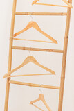 Des cintres suspendus sur une échelle en bois