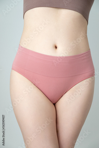 Close up photo of a woman's body. She is wearing pink underwear. Panties product shot. The woman is caucasian and has pale skin © Angela