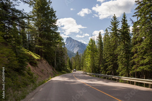 Traveling on asphalt highway and Rocky mountains in pine forest at Banff national park, Canada