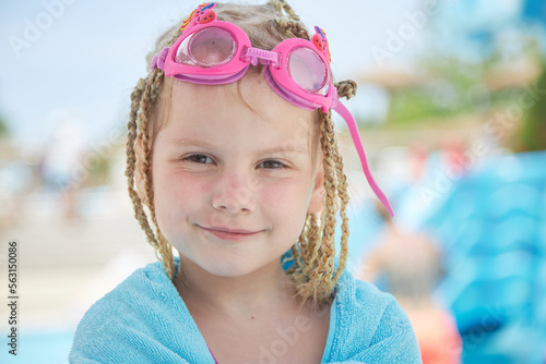 child girl 4 years old swims in the pool in the summer outdoors