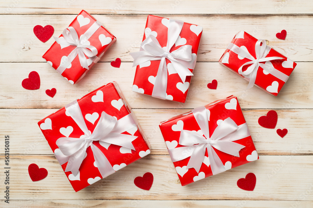 Gift boxes with hearts on wooden background, top view Gift boxes with hearts on wooden background, top view