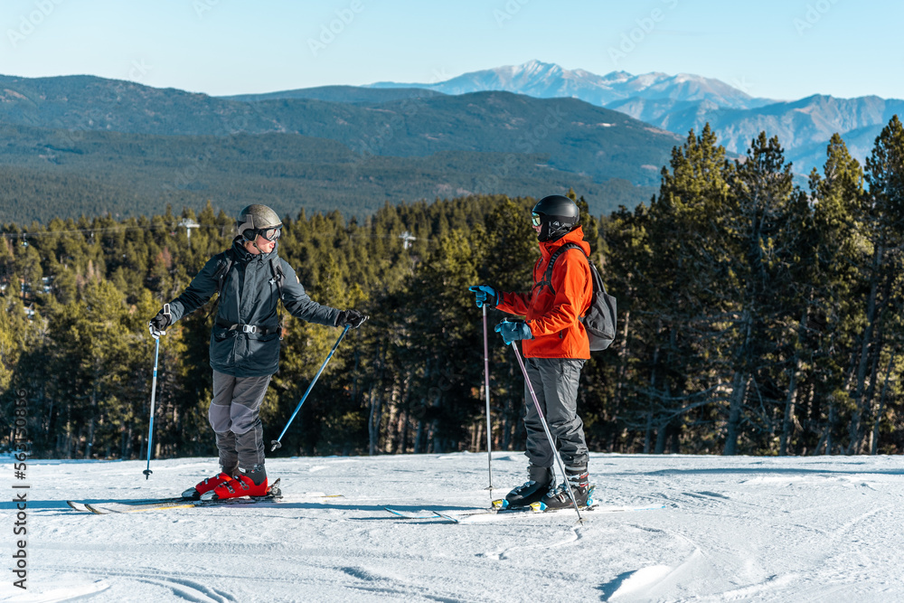 Two boys talking on a ski slope.