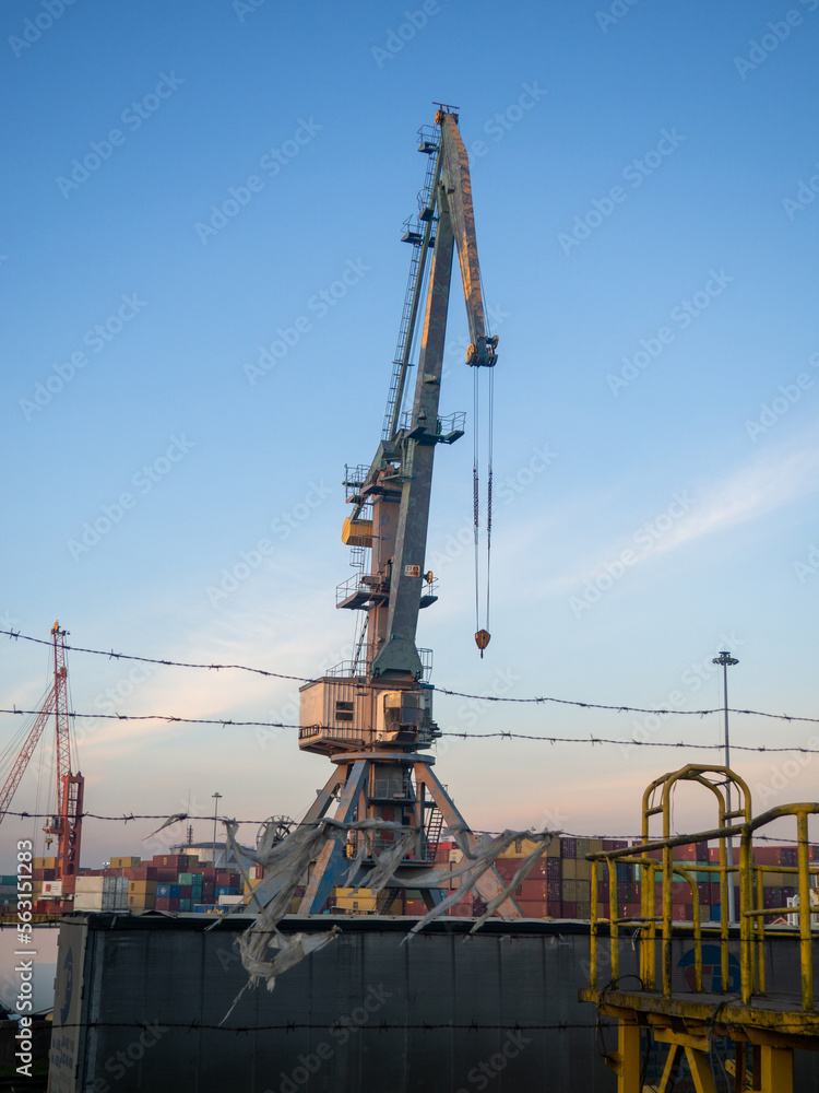 Loading port crane. Loading cargo. Maritime business. Industry. High crane on the sea. Port area