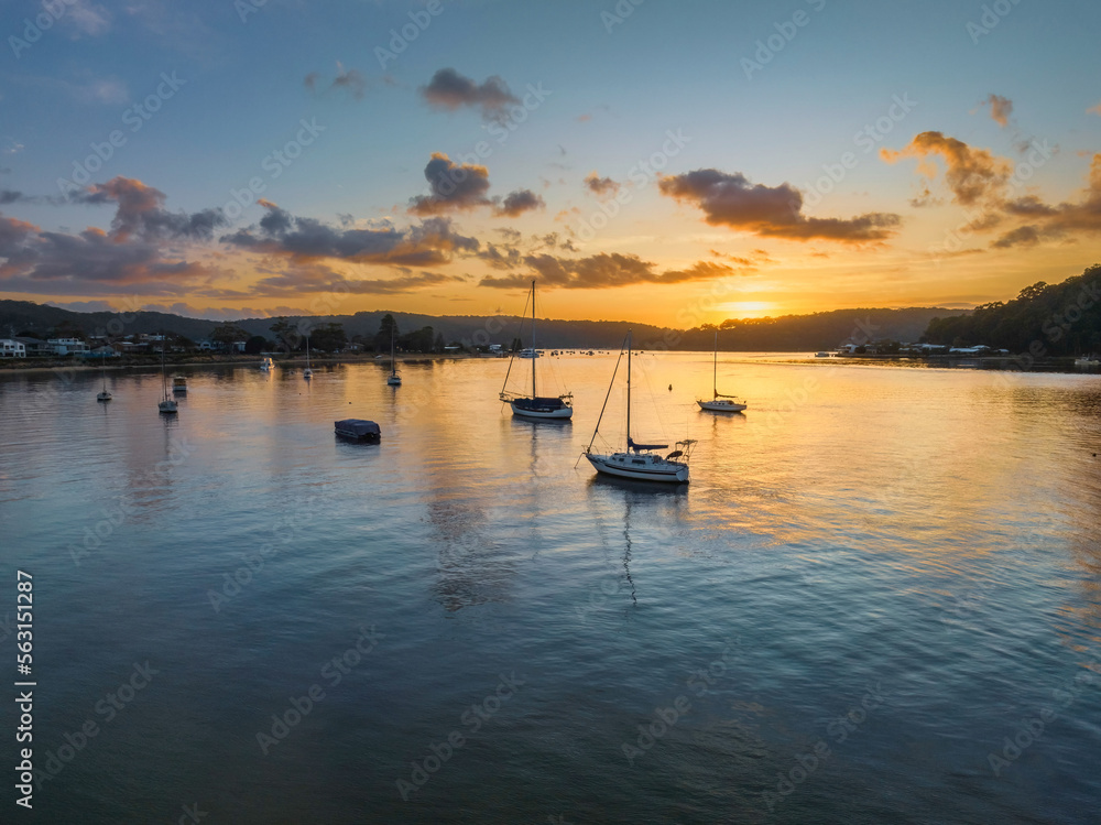 Aerial sunrise waterscape with boats and scattered clouds