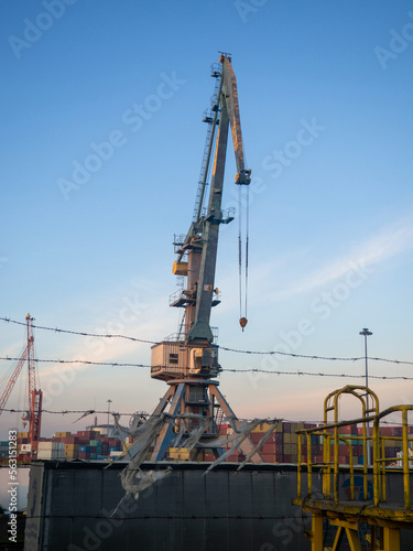 Loading port crane. Loading cargo. Maritime business. Industry. High crane on the sea. Port area