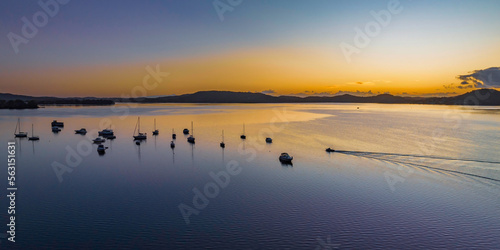 Aerial sunrise waterscape over the bay with boats © Merrillie