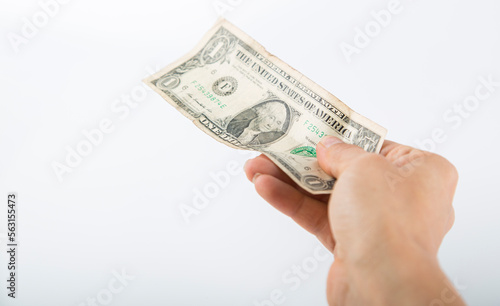 a person hands over a one-dollar bill