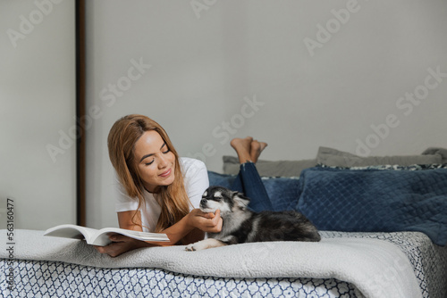 Mulher lendo com os filhotes de cachorro, pomsky, cães de raça