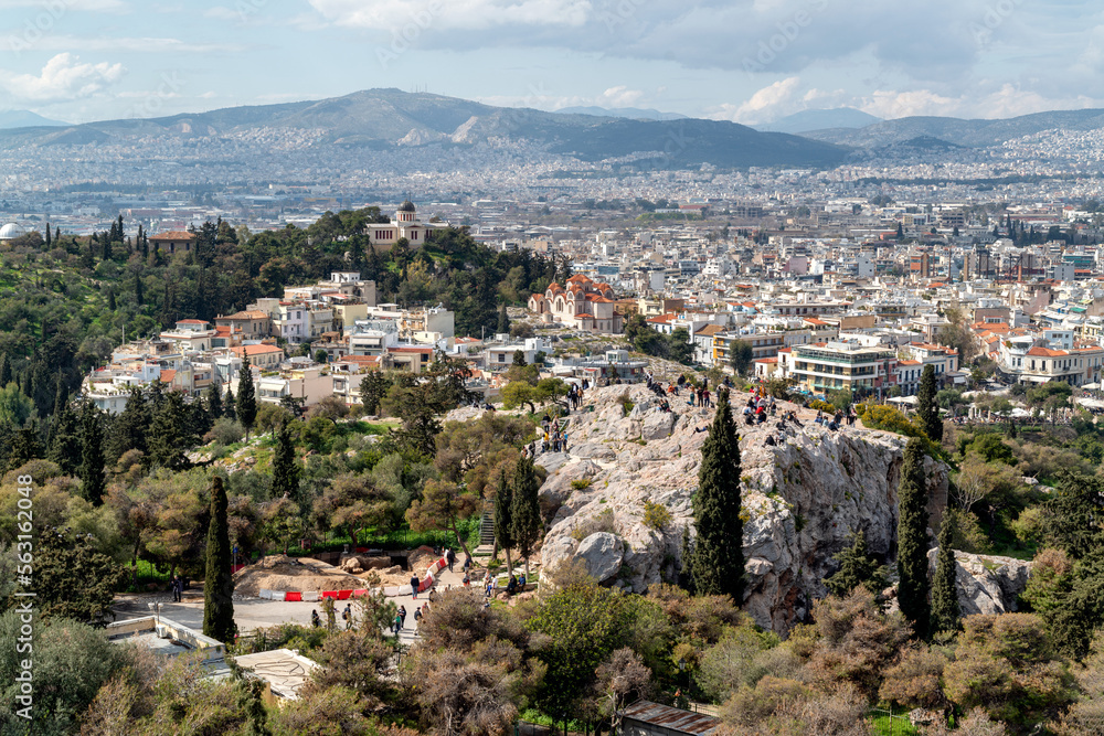 Panoramic view to Athens as seen from the Acropolis. People at the Areopagus Hill enjoying the view to Athens, the old National Observatory ontop the Nymphs hill