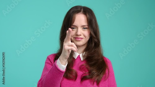 Portrait of caucasian, brunette-haired woman showing threatening gesture. Close-up shot of smiling, cute girl looking at camera. High quality 4k footage