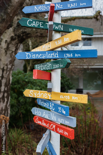 Colorful direction arrow signs on wooden pole. Direction to different places of the world indicated in a street sign © Elena_Alex