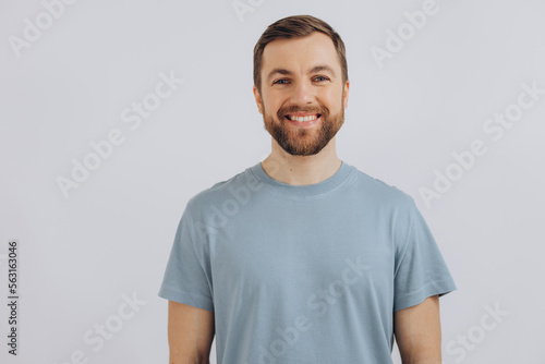 Portrait of a modern bearded middle-aged man in a blue t-shirt showing emotions on a white background