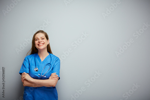Nurse in blue medical suit, portrait with copy space on wall.