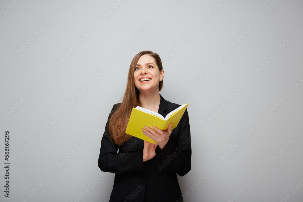 Portrait of smiling girl student or woman teacher holding book looking up. Portrait of smiling girl student or woman teacher holding book looking up.
